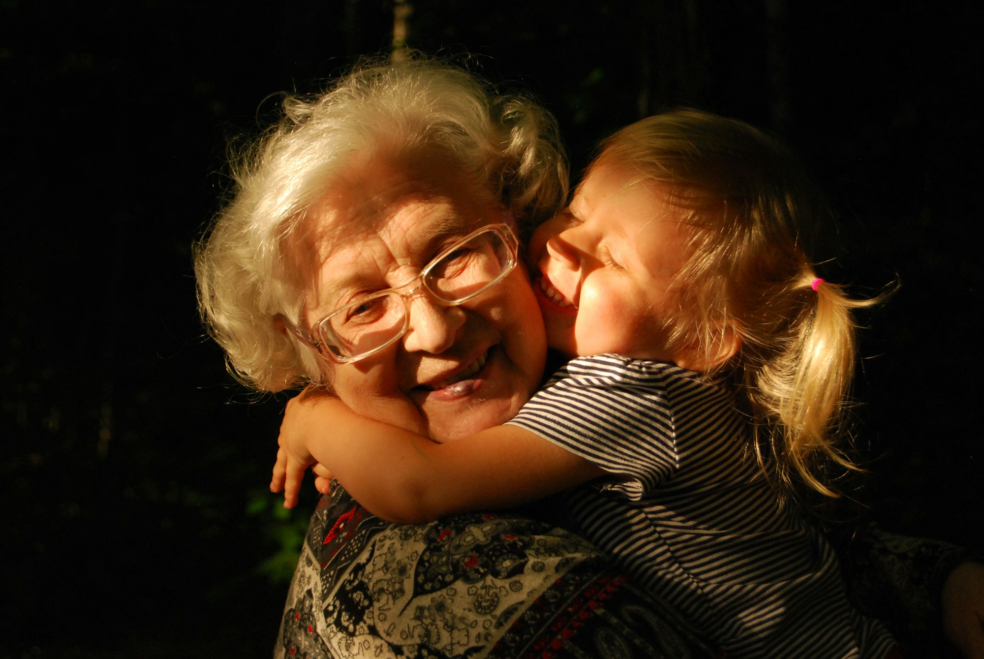A grandmother hugging a young child