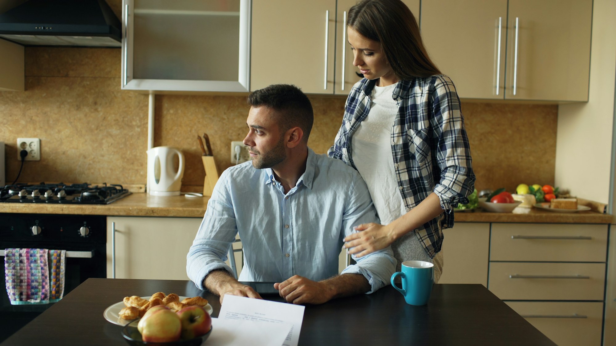 A couple talking together at the kitchen table