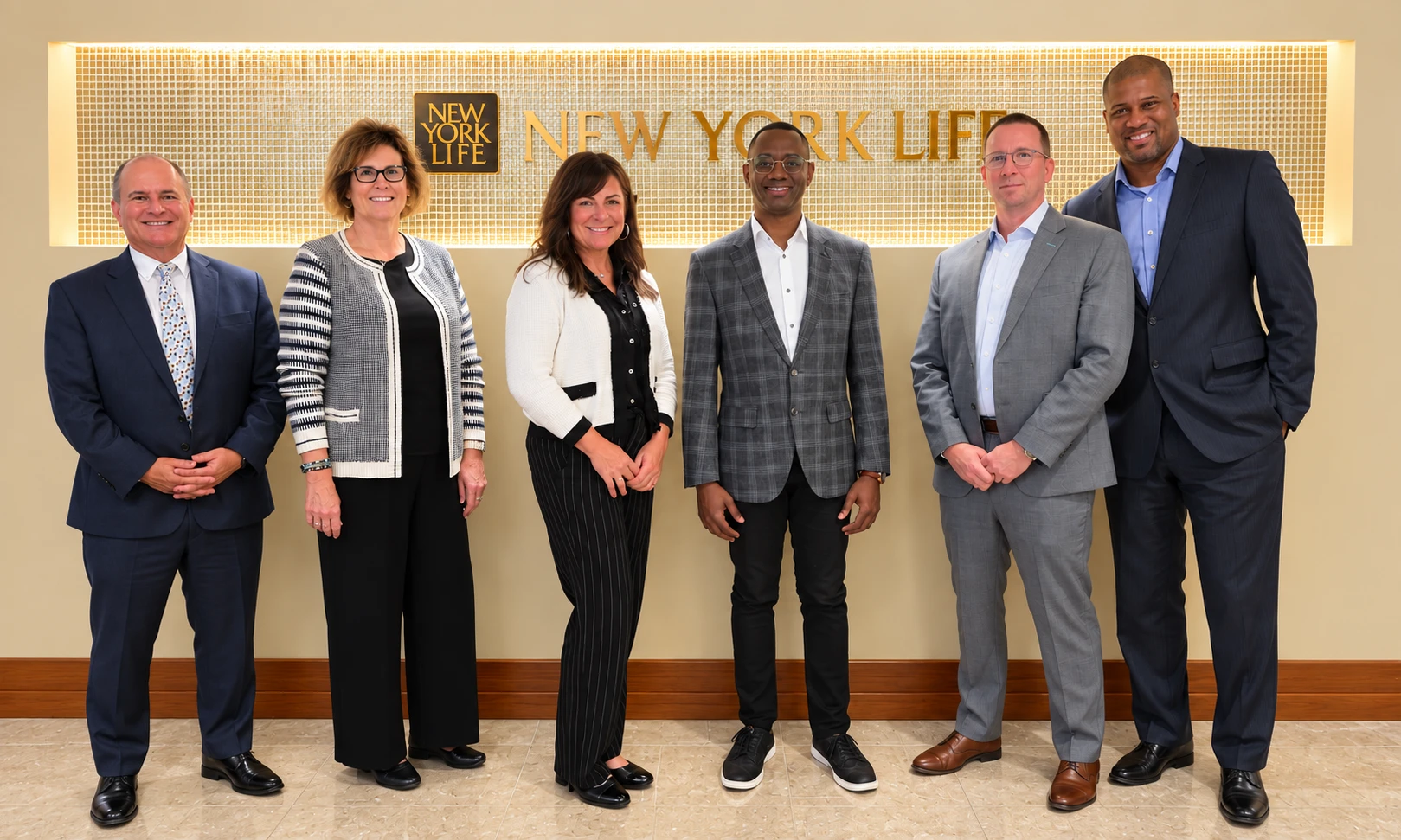 Six partners standing together in front of the New York Life sign