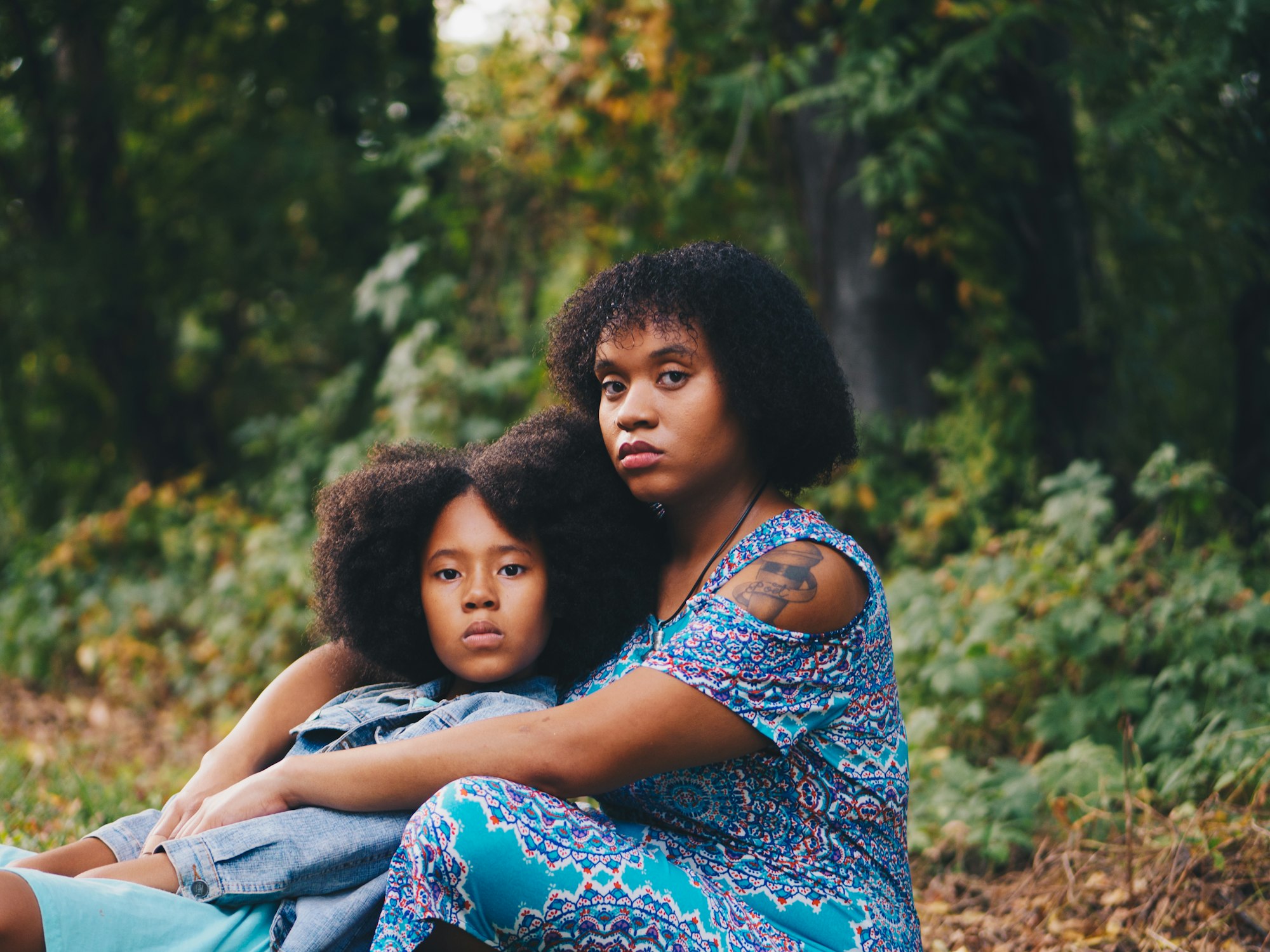 A mother and child sitting together under the trees