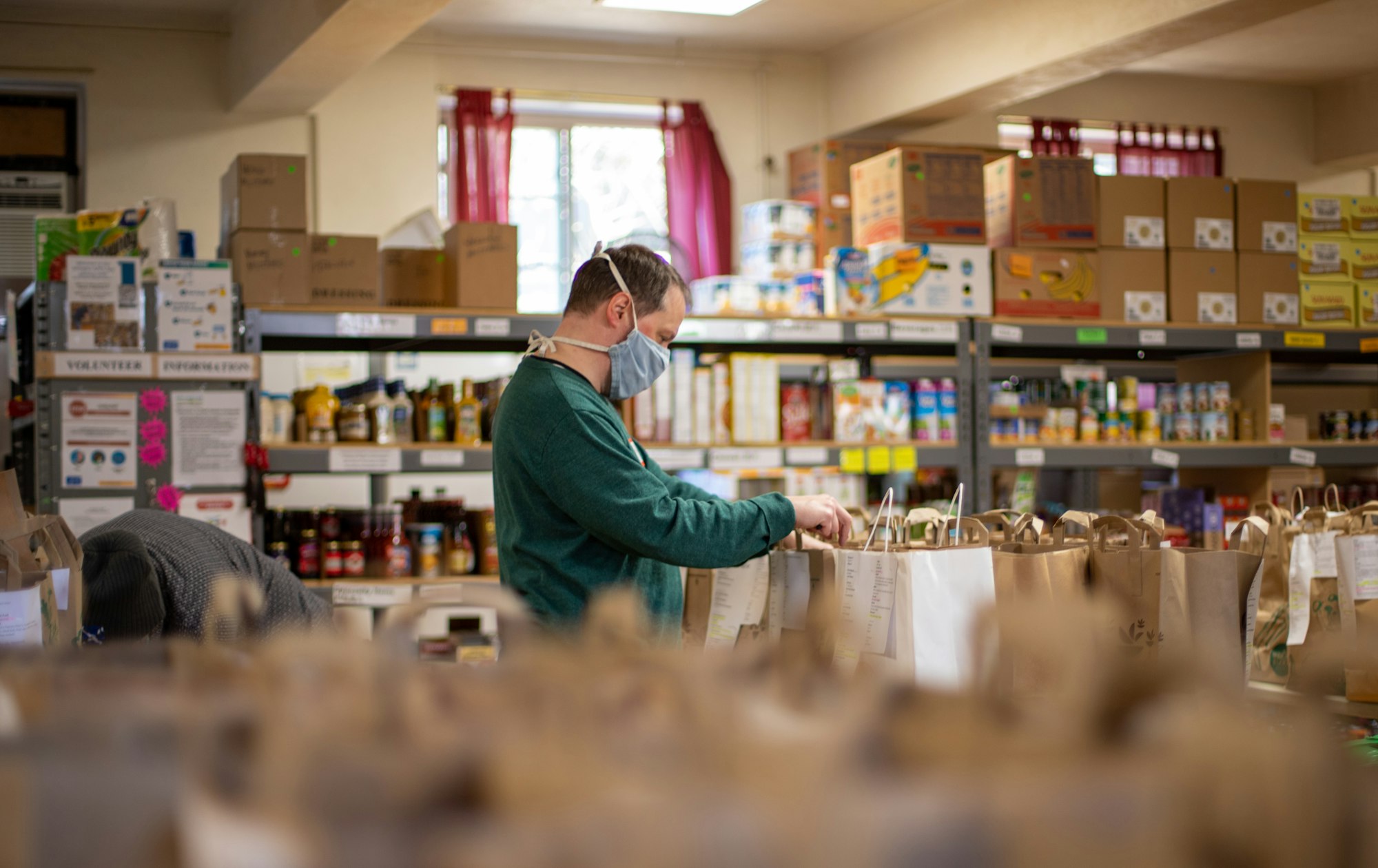 A volunteer organizing a community pantry